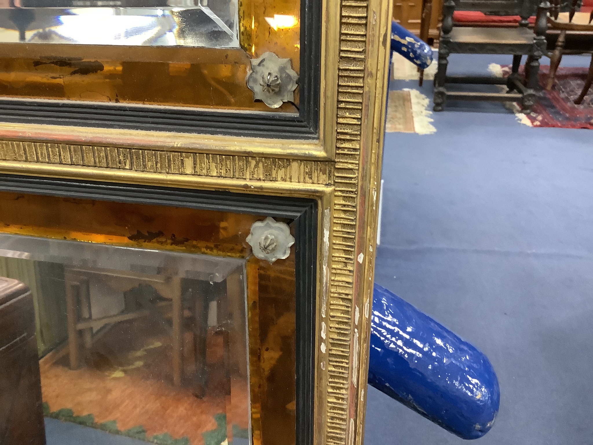 An 18th century moulded gilt overmantel, three mirror plates and amber glass borders and clear glass rosettes